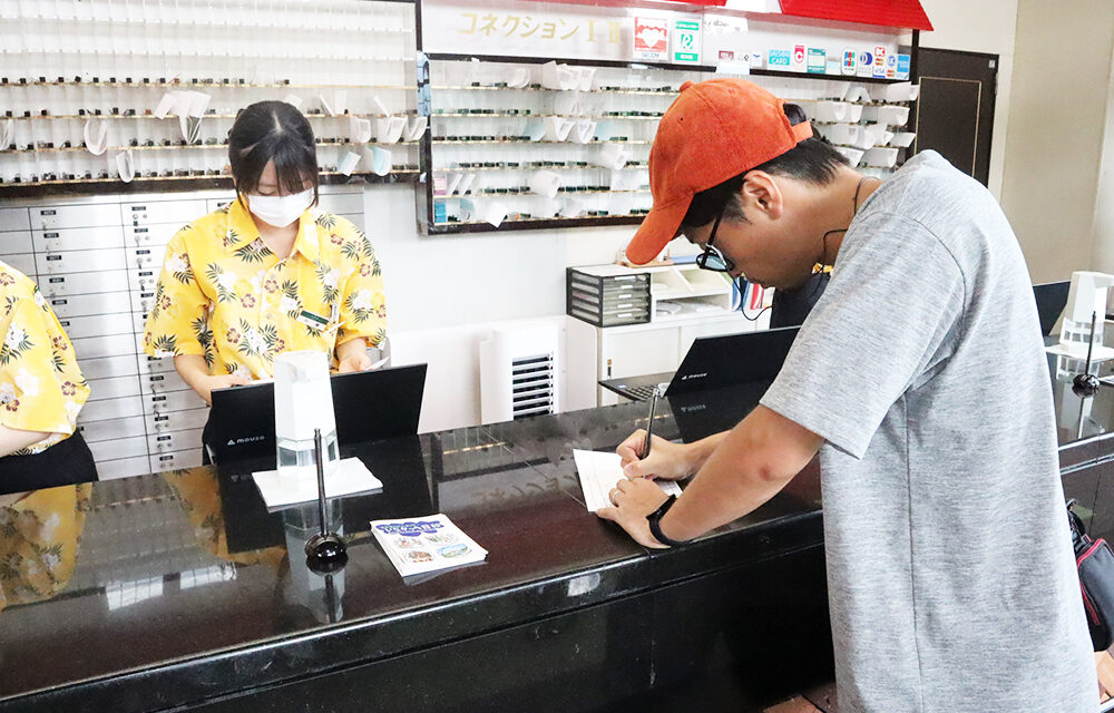 ホテルフロントにてチェックアウトをする男性の写真